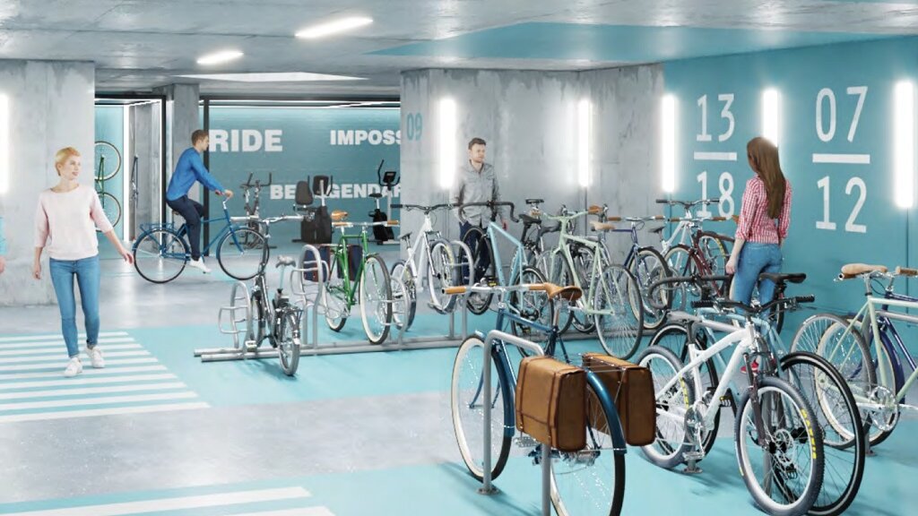 Innenansicht einer Fahrradgarage mit Fahrrädern und Menschen.